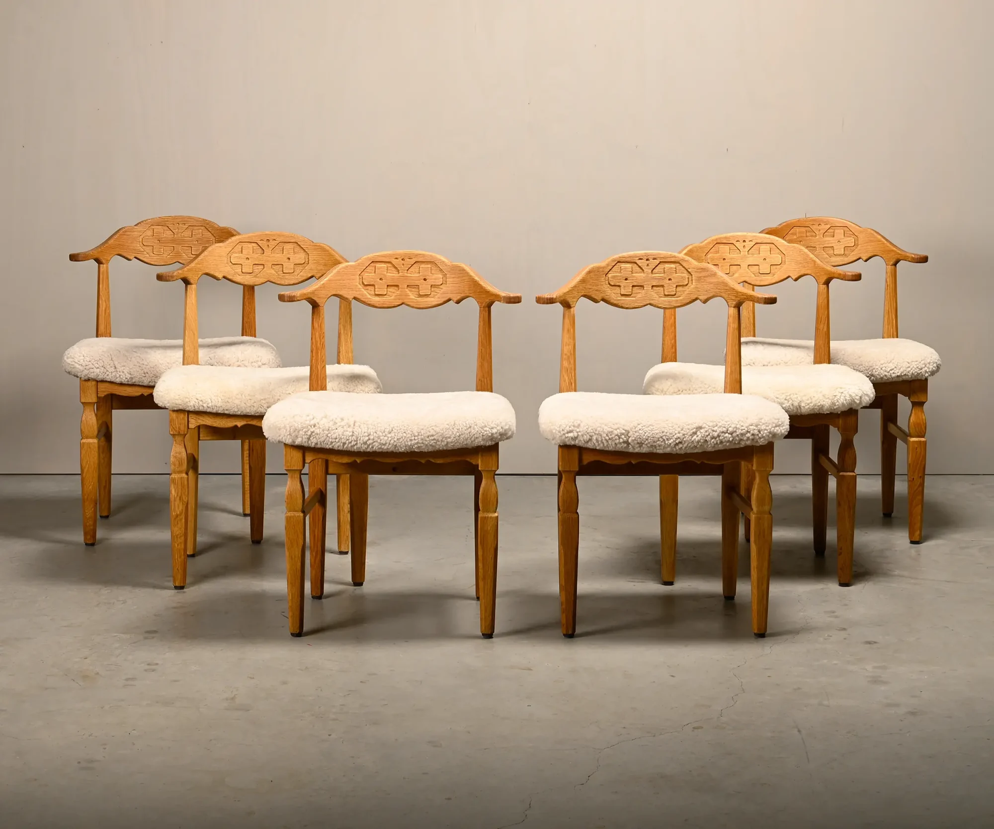 Henning Kjærnulf dining chairs set in Oak and Sheepskin, Denmark, 1960s