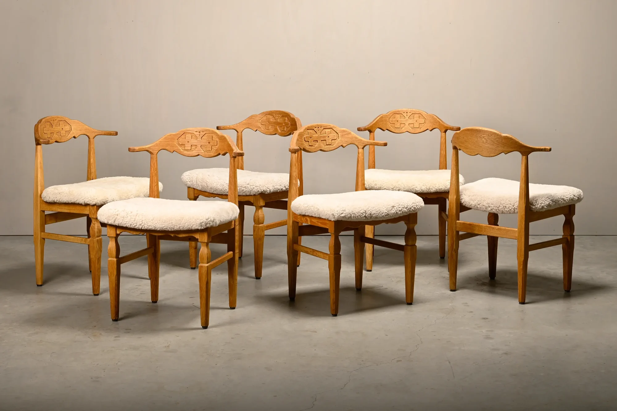 Henning Kjærnulf dining chairs set in Oak and Sheepskin, Denmark, 1960s